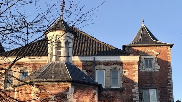 Un bâtiment historique doté d’une tour imposante et d’une façade en briques.
