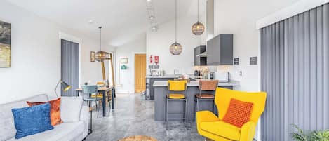 Una sala de estar moderna con un sofá, una mesa de centro y una silla de color amarillo brillante.