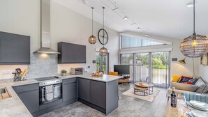 Una cocina moderna con una isla central, electrodomésticos integrados y un comedor con vistas.