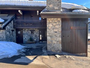 A stone building with a wooden balcony, a stone chimney, and a wooden door.