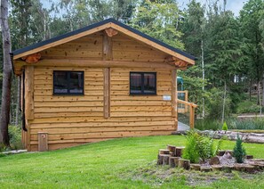 Une cabane en bois avec deux fenêtres, une véranda et une enseigne portant l’inscription « PRIMROSE ».