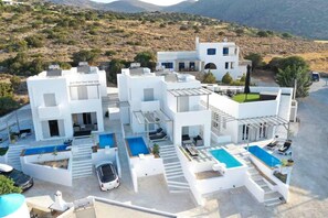 A modern white building with multiple balconies and a swimming pool area. - White Villas Paros With Private Pool (Paros)