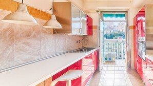 A modern kitchen with marble countertops, pendant lights, and a view through an open door to a balcony. - GuestHost - JJ'S Place Trieste Apartment (Trieste)