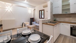 Eine moderne Küche mit weißen Schränken, einer Holz Arbeitsplatte und einem eingebauten Backofen.
