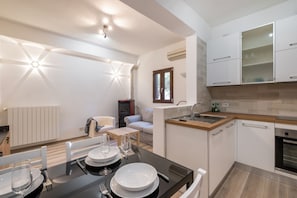 A modern kitchen with white cabinets, a wooden countertop, and a built-in oven.