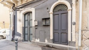 A building with two large doors, a small mailbox, and a number '20' above the right door. - GuestHost - Catania Central Design Studio near the Station (Catania)