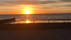 A sunset over the ocean with a paved walkway and a railing. - Edwardian Villa by the Sea,coastal Walks,king Beds (Walton on the Naze)