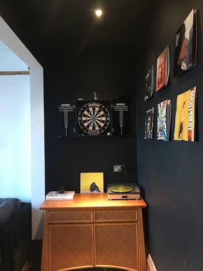 A room with a dartboard, a record player, and various posters on the wall. - Edwardian Villa by the Sea,coastal Walks,king Beds (Walton on the Naze)