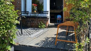A corner house with a bay window, a wooden deck, and a small outdoor seating area. - Edwardian Villa by the Sea,coastal Walks,king Beds (Walton on the Naze)