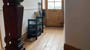 A wooden staircase leading to a room with a wooden floor, a door with glass panels, and a coat rack with hats. - Edwardian Villa by the Sea,coastal Walks,king Beds (Walton on the Naze)