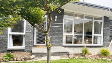 A modern house with a stone exterior, large windows, and a welcoming 'Welcome' sign.