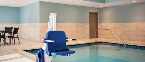 Una piscina con una silla azul y un perchero.
