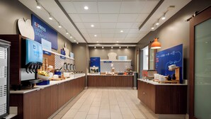 Un área de desayuno moderna con señalización de marca, una variedad de alimentos y un piso de baldosas impecable.