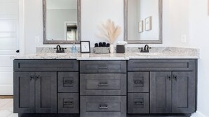 A bathroom with a double vanity, two large mirrors, and a granite countertop. - Luxe 3BR Family Stay | Fenced Yard | Prime WR (Kathleen)
