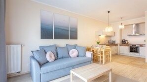 Ein modernes Wohnzimmer mit Sofa, Couchtisch und Essbereich.