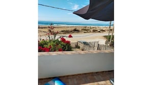 Ein Balkon mit Blick auf Strand und Meer.