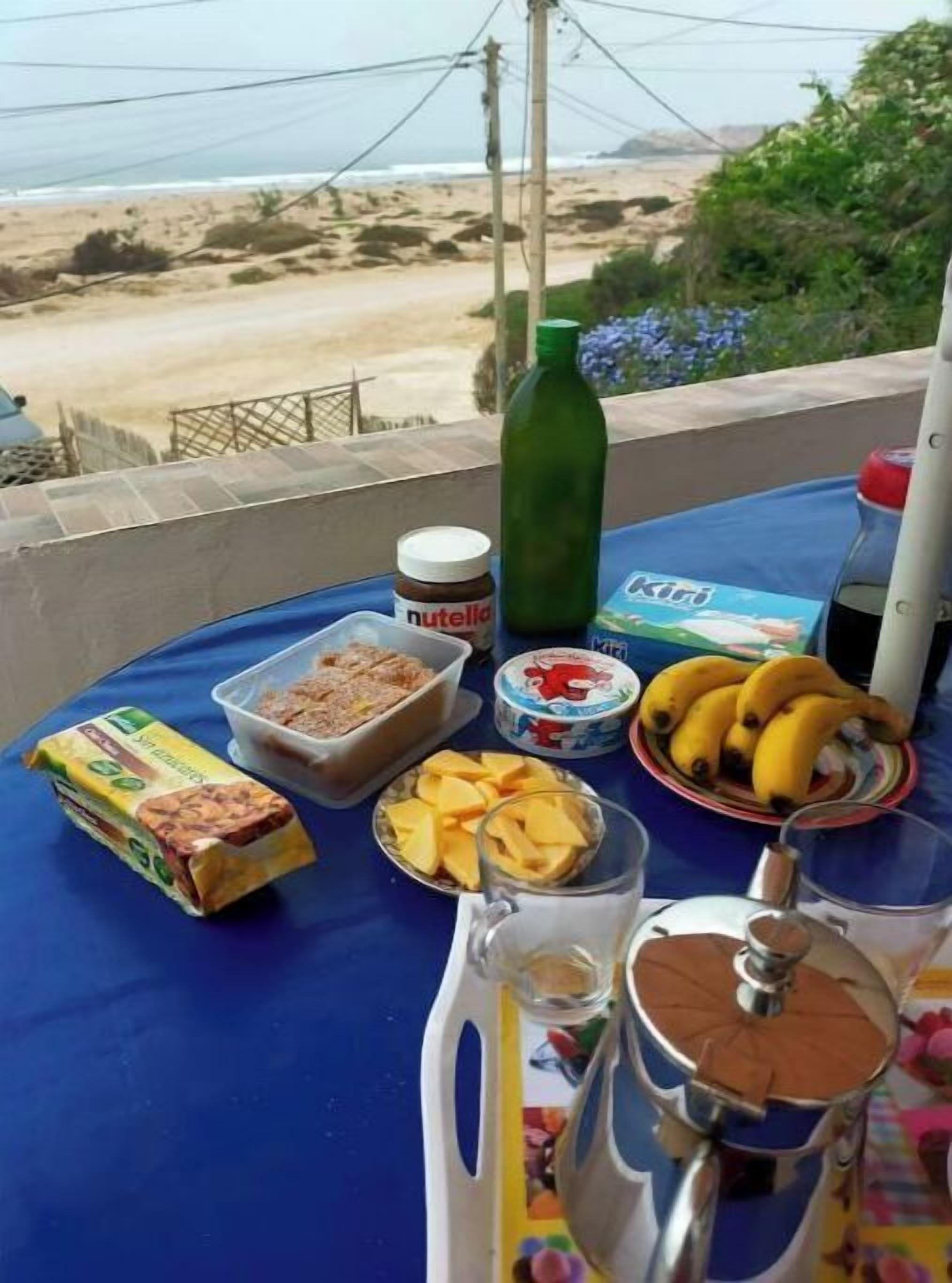 Una mesa con comida y vista a la playa.