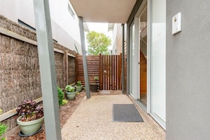 Stroll through this serene outdoor corridor, lined with lush greenery and a charming table setting.