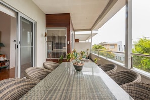 Enjoy dining al fresco on the balcony with a table set for two, surrounded by wicker chairs.