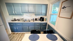 A kitchen with blue cabinets, a coffee maker, and a window with a view of the outdoors. - Spacious Home 8 min to ND and Memorial Hospital (South Bend)