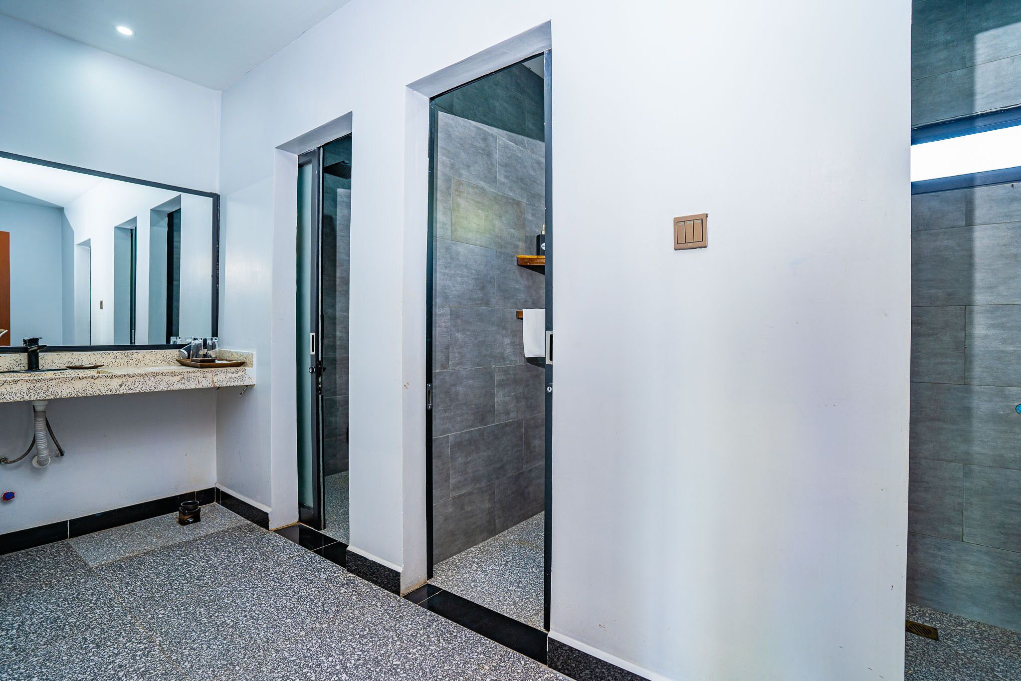 Un baño moderno con cabina de ducha de vidrio, un lavabo con encimera y un espejo.