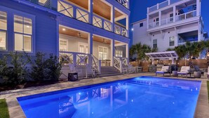 Un bâtiment à deux étages doté d’une piscine, d’un espace extérieur aménagé et d’un patio couvert.