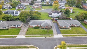 Una vista aerea di una zona residenziale con case, strade e aree verdi.