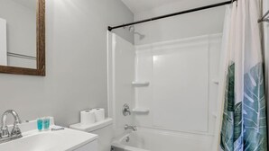 Un bagno con lavandino, water e vasca da bagno bianchi.