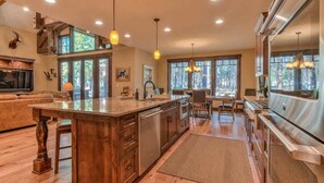 A spacious kitchen with a large island, wooden cabinetry, and modern appliances. - AC, gourmet kitchen, pet friendly, Luxury (Sunriver)