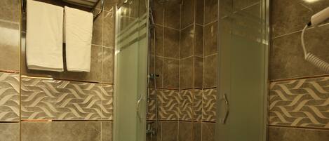 Un baño moderno con ducha envuelta en vidrio, un inodoro y un lavabo.