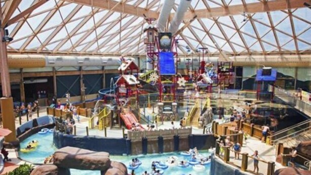 Un parc aquatique intérieur doté de nombreux toboggans, de piscines et de bouées gonflables.