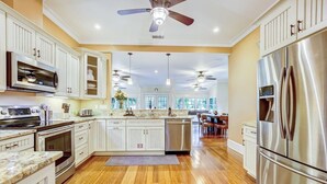 A spacious kitchen with white cabinetry, stainless steel appliances, and a wooden floor. - Lakeside Retreat |Private Pool| 8min walk Downtown (Saint Augustine)