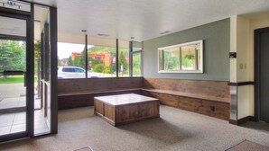 A hotel lobby with a large bench, a reception desk, and a view of the outside. - Spacious Condo, Short Walk to Lifts. SH301 (Copper Mountain)