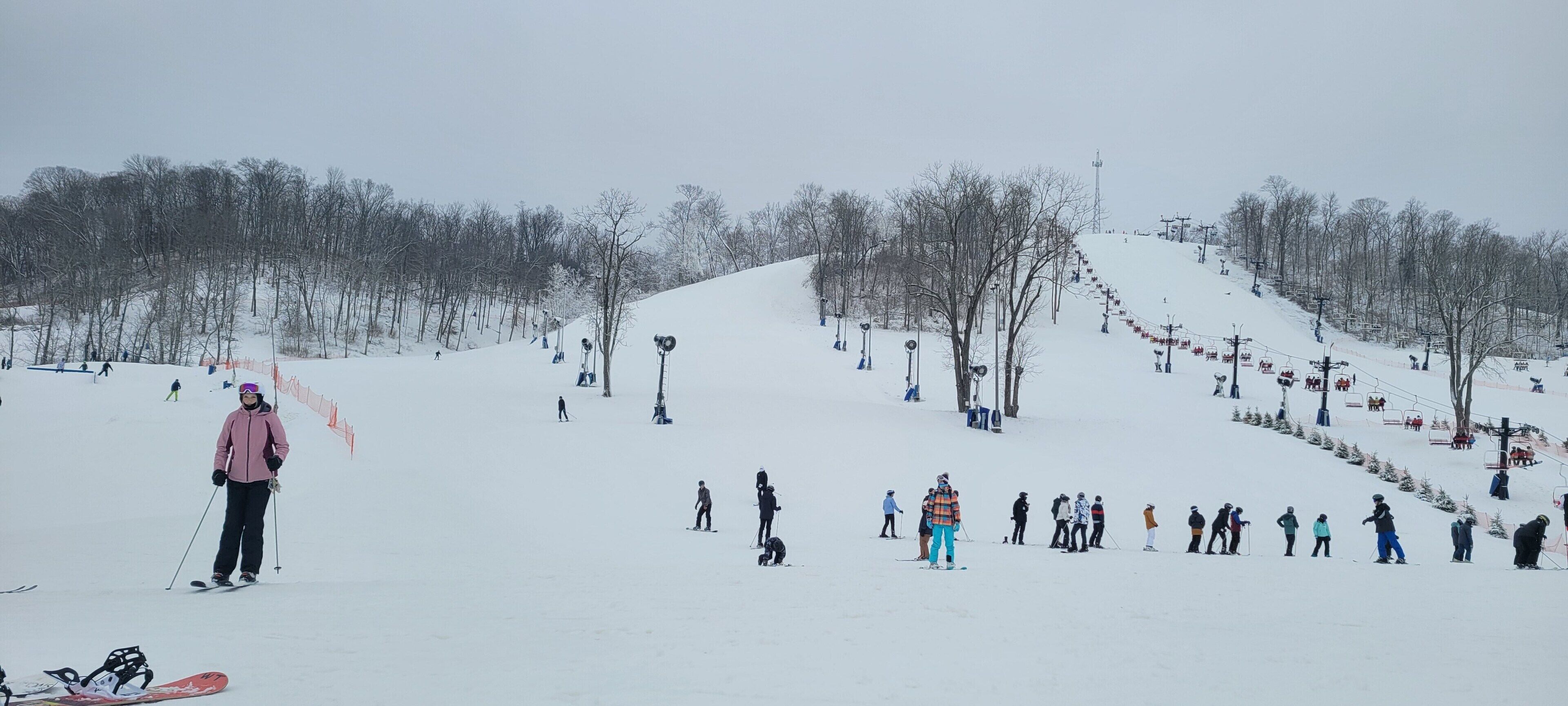 Une piste de ski enneigée avec des skieurs et un télésiège.