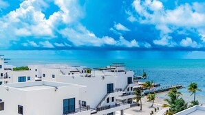 A modern hotel with white architecture, multiple balconies, and a view of the sea. - All Shades of Blu -Best Resort in Caye Caulker (Caye Caulker)