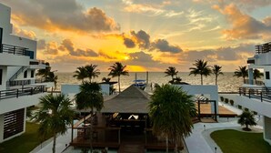 A resort with a pool area, palm trees, and a sunset view. - All Shades of Blu -Best Resort in Caye Caulker (Caye Caulker)