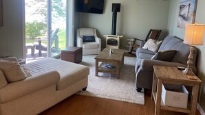 Een gezellige woonkamer met een bank, een fauteuil, een salontafel en een open haard.