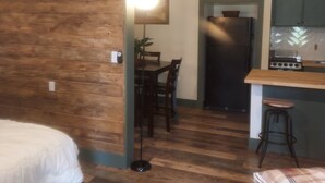 Ein kleines Zimmer mit Bett, Schreibtisch und einer Küchenzeile.
