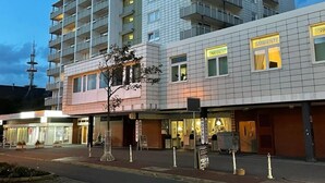 Ett modernt hotell med flera våningar, balkonger och en väl synlig restaurang som heter ”Hansel”.
