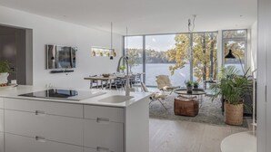 A modern kitchen with a large island, a dining area with a view of the lake, and a cozy seating area with a view.