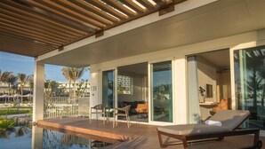 A modern outdoor pool area with lounge chairs, a wooden deck, and a glass-enclosed living space. - Redefining luxury one click at a time (Ho Chi Minh City)