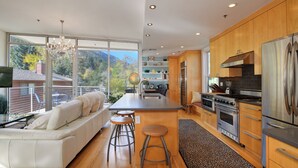 Una cocina moderna con una isla grande, electrodomésticos de acero inoxidable y vistas a las montañas.