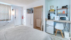 A compact kitchen with a microwave, coffee maker, and a small refrigerator.