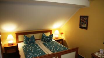 A neatly made bed with patterned bedding, two bedside lamps, and a framed picture on the wall.