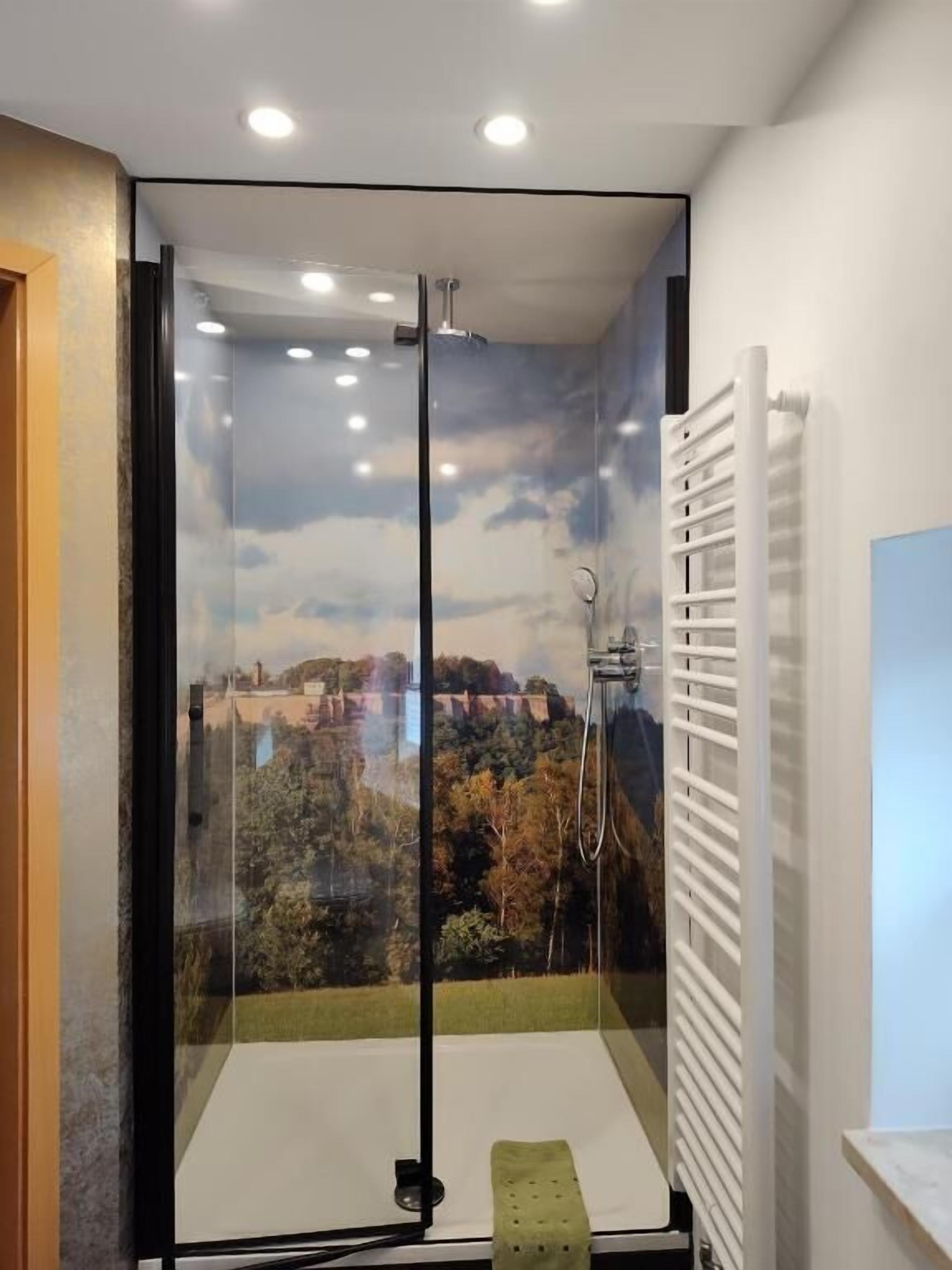 A modern bathroom with a glass-enclosed shower, a white radiator, and a view of a cityscape through the shower door.
