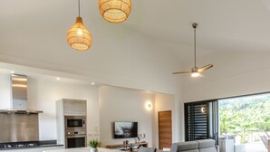 A modern kitchen with a central island, bar stools, and pendant lighting. - Amazing Waterfront Villa fully equipped w/ infinity pool (Moorea-Maiao)
