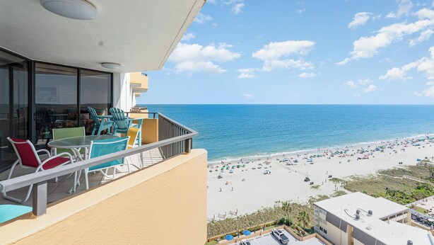 A balcony with a view of the beach and ocean.