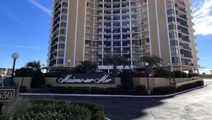 A multi-story hotel with a prominent sign reading "Mansion-sur-Mer" at the entrance.