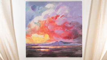 A painting of a sunset landscape with mountains in the background.