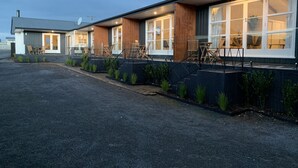 En modern byggnad med stora fönster och uteservering.